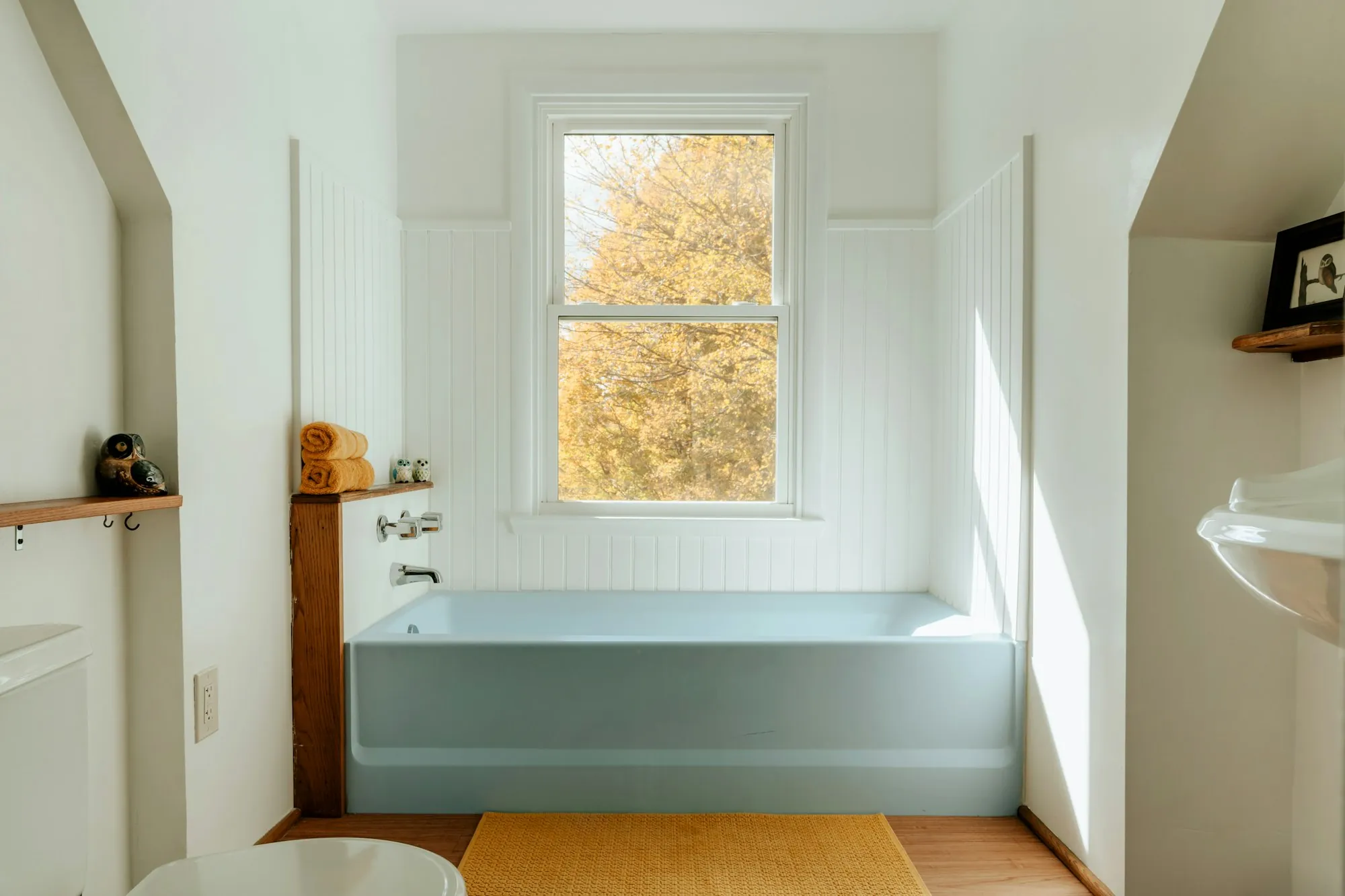 A bathroom with a bath, a basin and daylight through the window