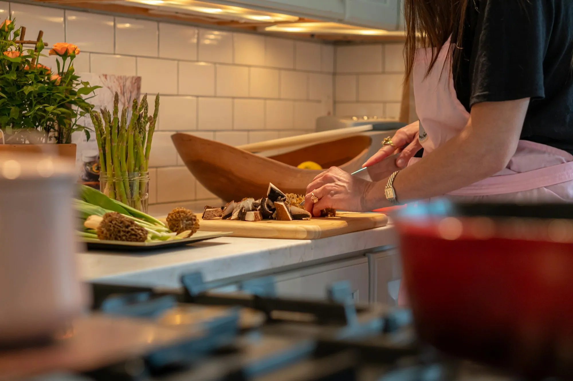 A woman chopping vegetables on a board in a home kitchen