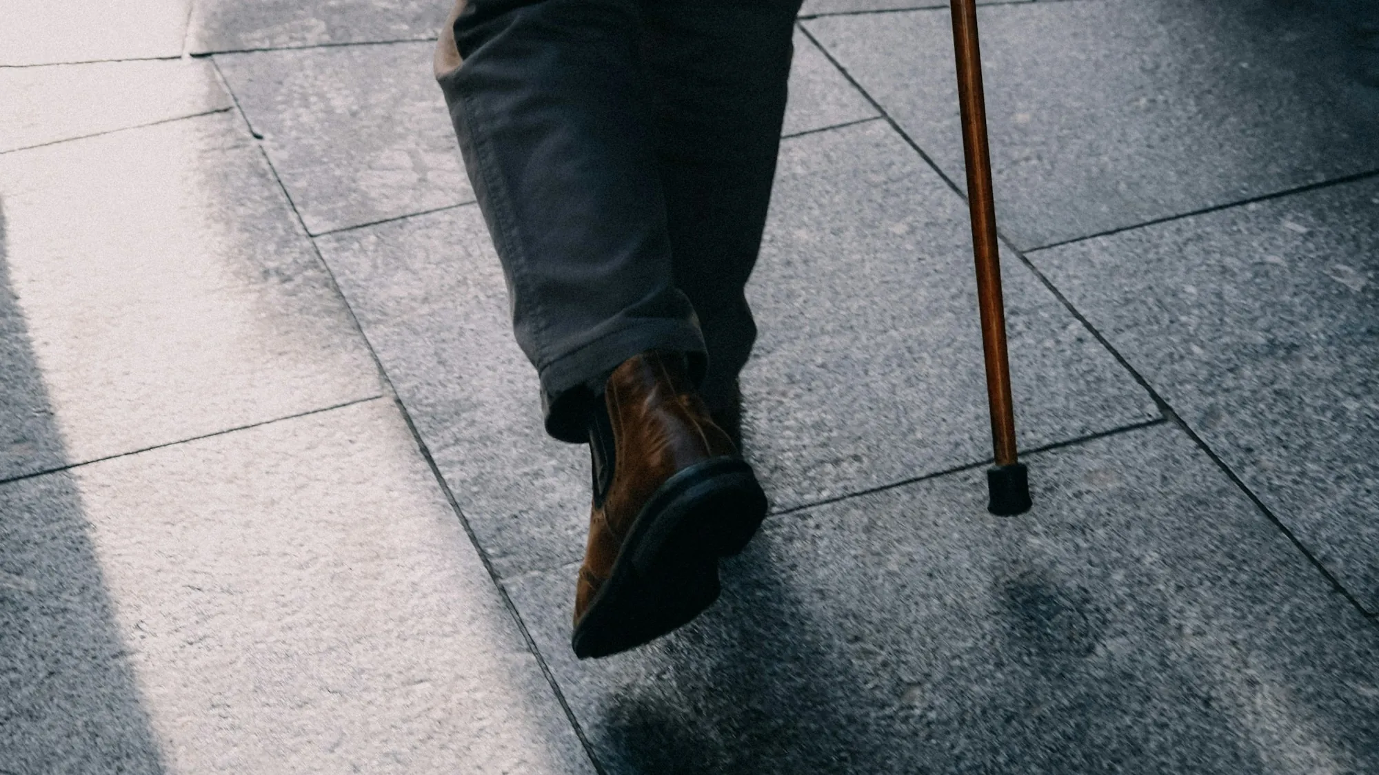 Hands resting on the handle of a walking stick